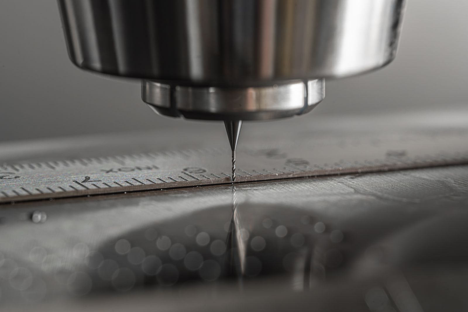 CNC drill bit machining a precision metal surface